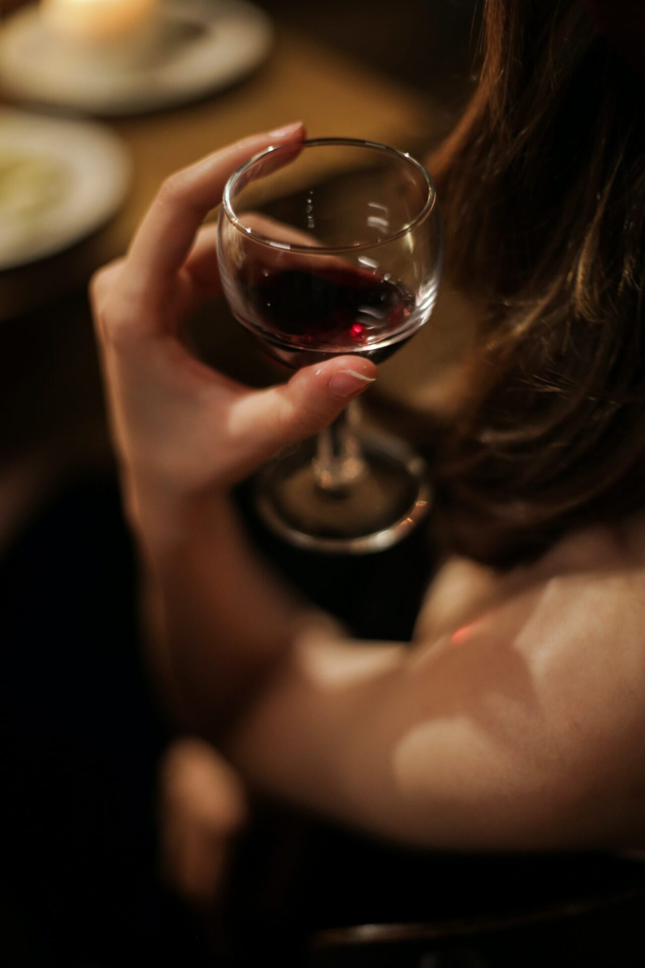 Looking over the shoulder of a female holding glass of red wine at our Tampa, FL hotel