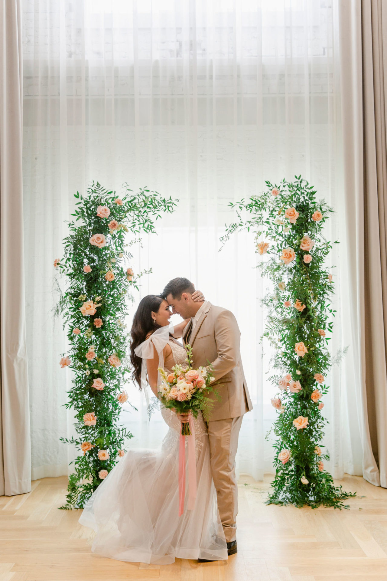 Bride and groom posing in front of pink flowers at our Ybor City hotel