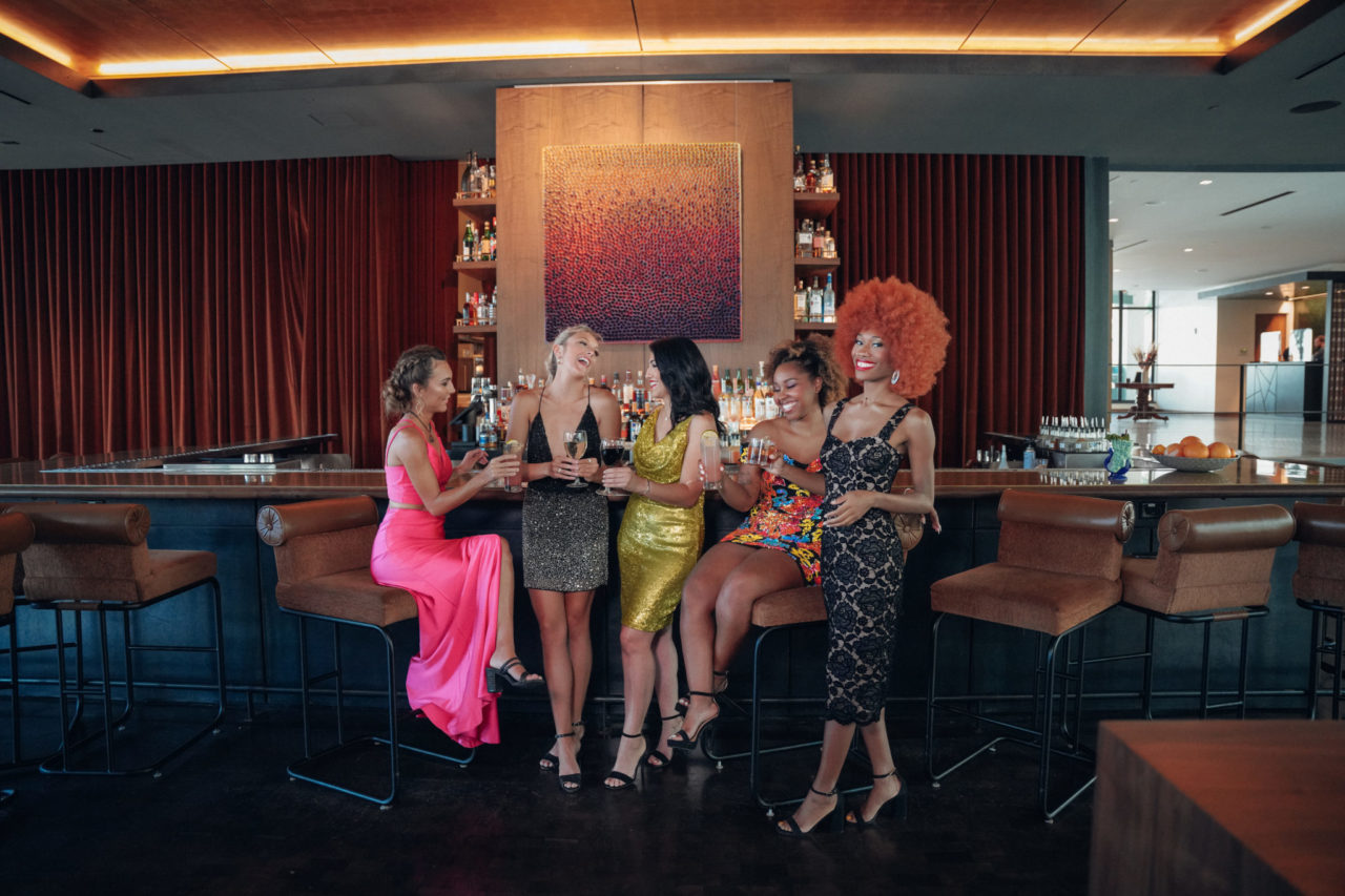Group of women dressed up and laughing at the bar of our Ybor City hotel